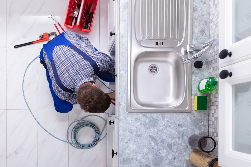Male Blue Collars Plumber Fixing Clogged Sink