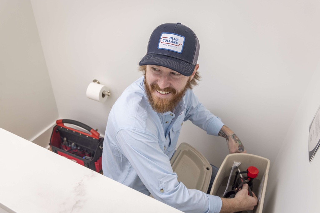 Blue Collars Plumber Fixing Leaking Toilet