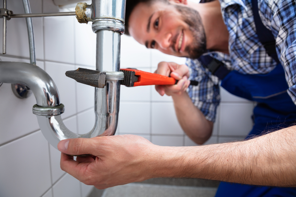 Male Blue Collars Plumber Fixing Leaky Sink